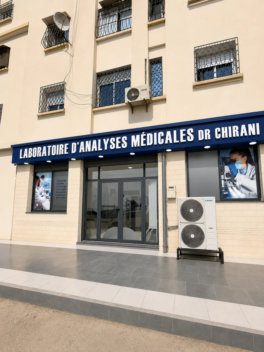 Façade du laboratoire d'analyses médicales avec son enseigne bleue et ses vitrines illustrées
