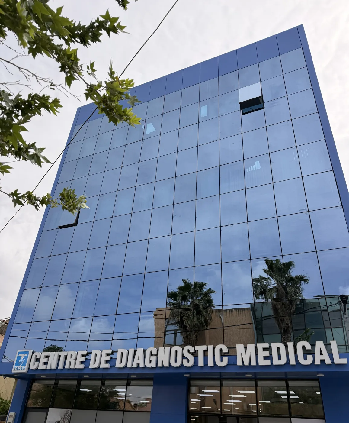 Façade vitrée bleue du centre de diagnostic médical avec son enseigne